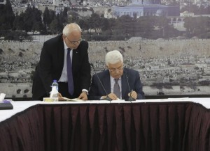 Handout picture showing Abbas signing international agreements in the West Bank city of Ramallah
